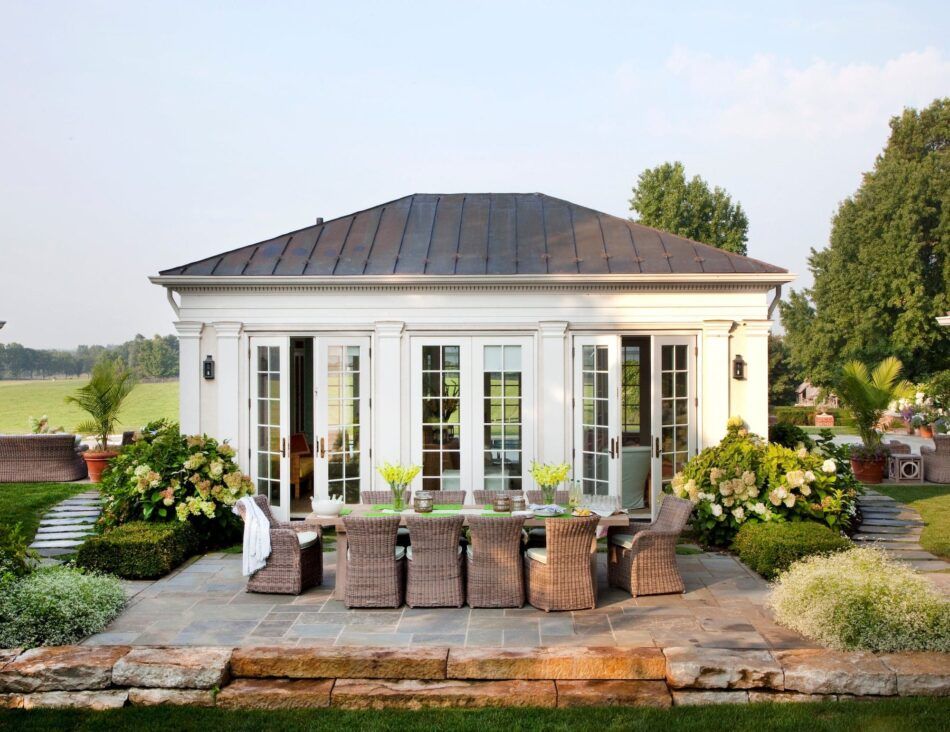 a traditional white pool house with french doors by Kemble Interiors designer Liza Morten Gioia