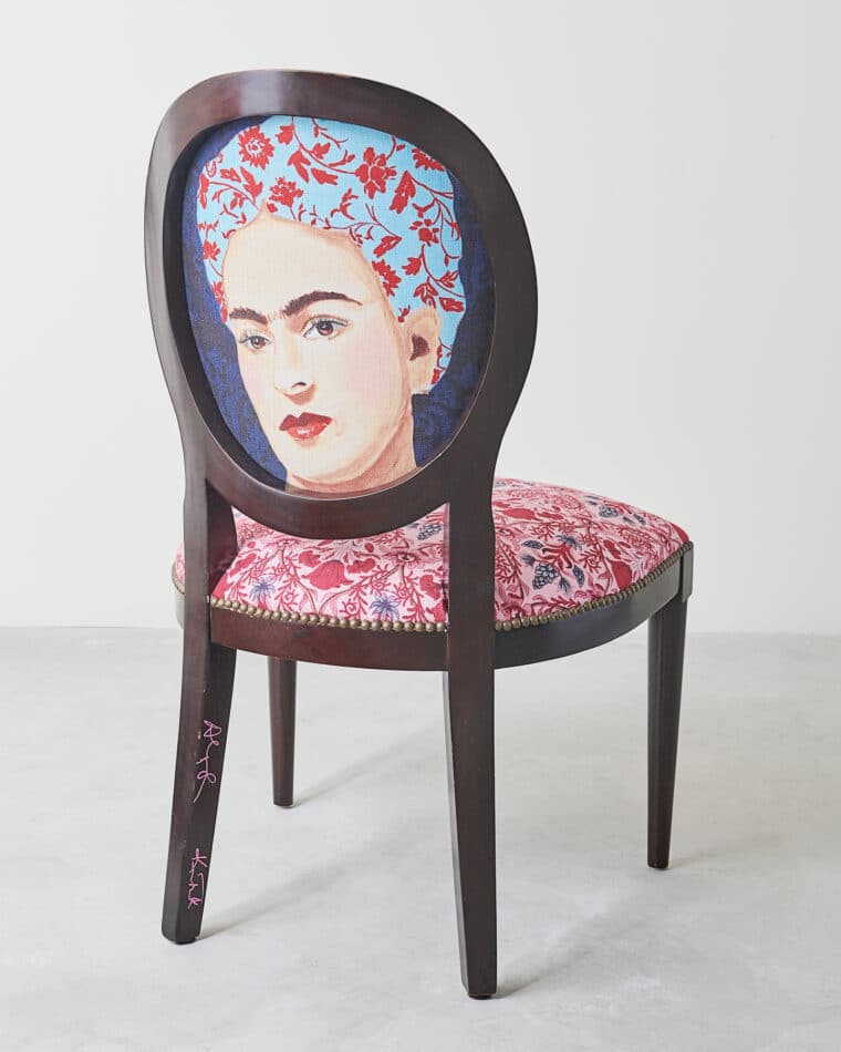A Ken Fulk x Ashley Longshore chair with a portrait of Frida Kahlo on the back