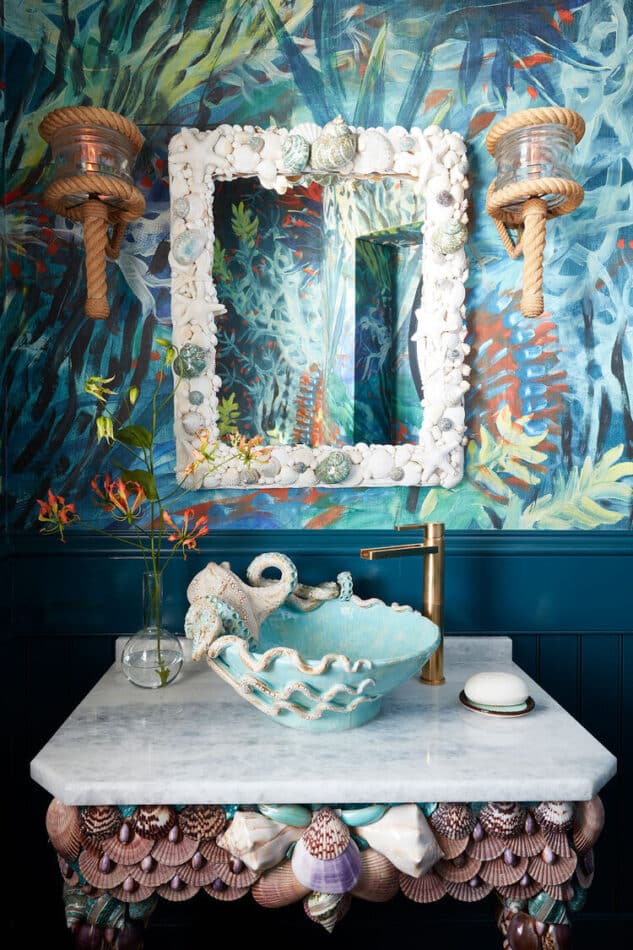 a sea-themed powder room with a seashell-covered sink