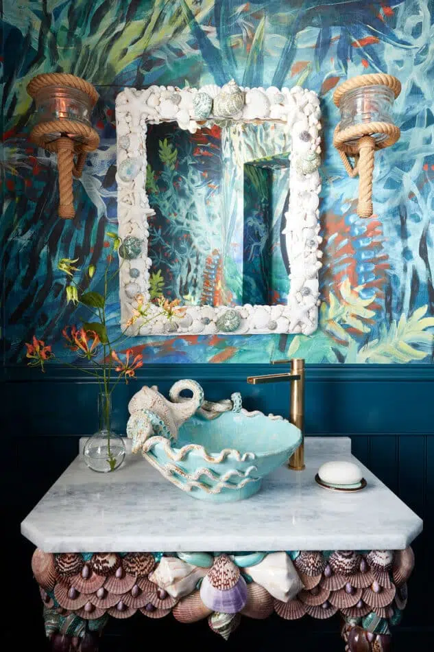 a sea-themed powder room with a seashell-covered sink