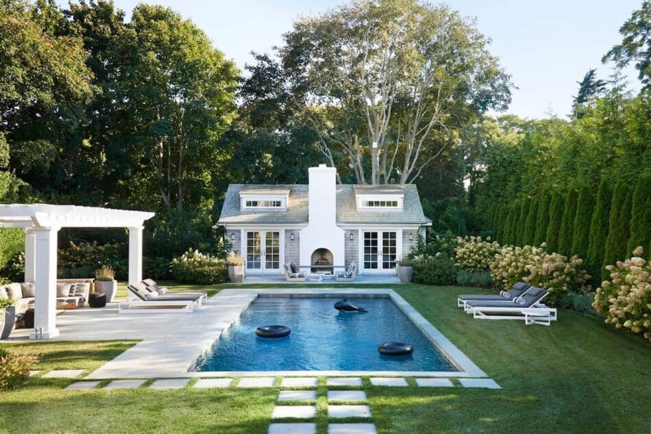 a shingle style pool house designed by Jessica Ayromloo with a pool