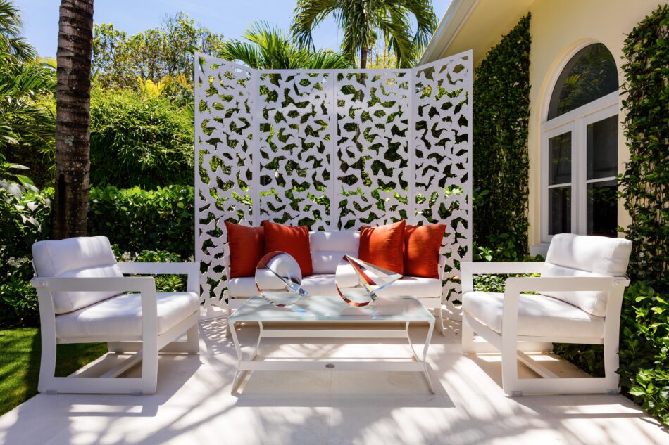 a white patio with a screen and seating