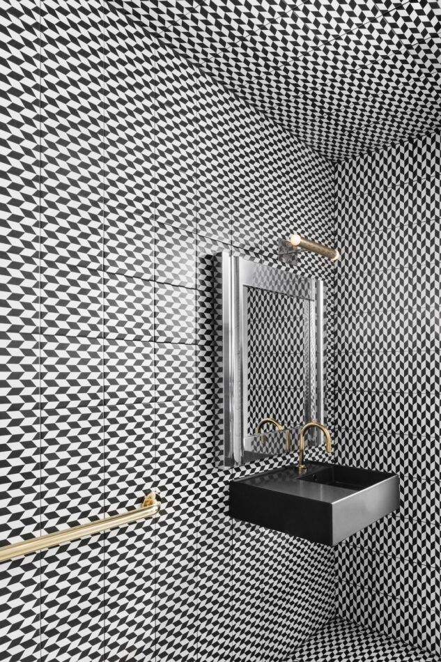 a patterned black and white powder room 