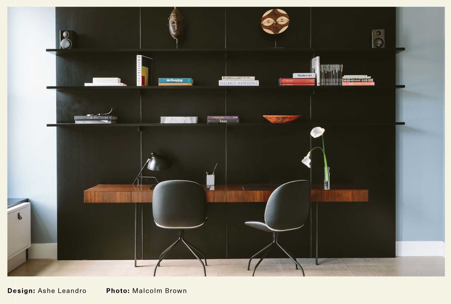 Ashe Leandro interior with contemporary desk against a black wall and a minimal bookshelf