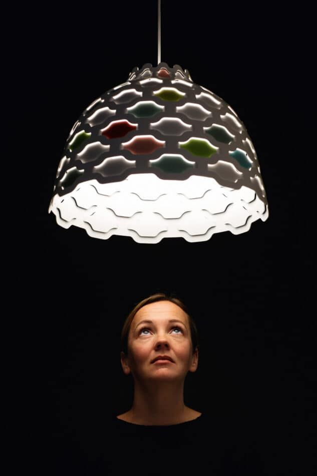 Louise Campbell with the Shutters Collage pendant lamp, as seen in the book Danish Lights