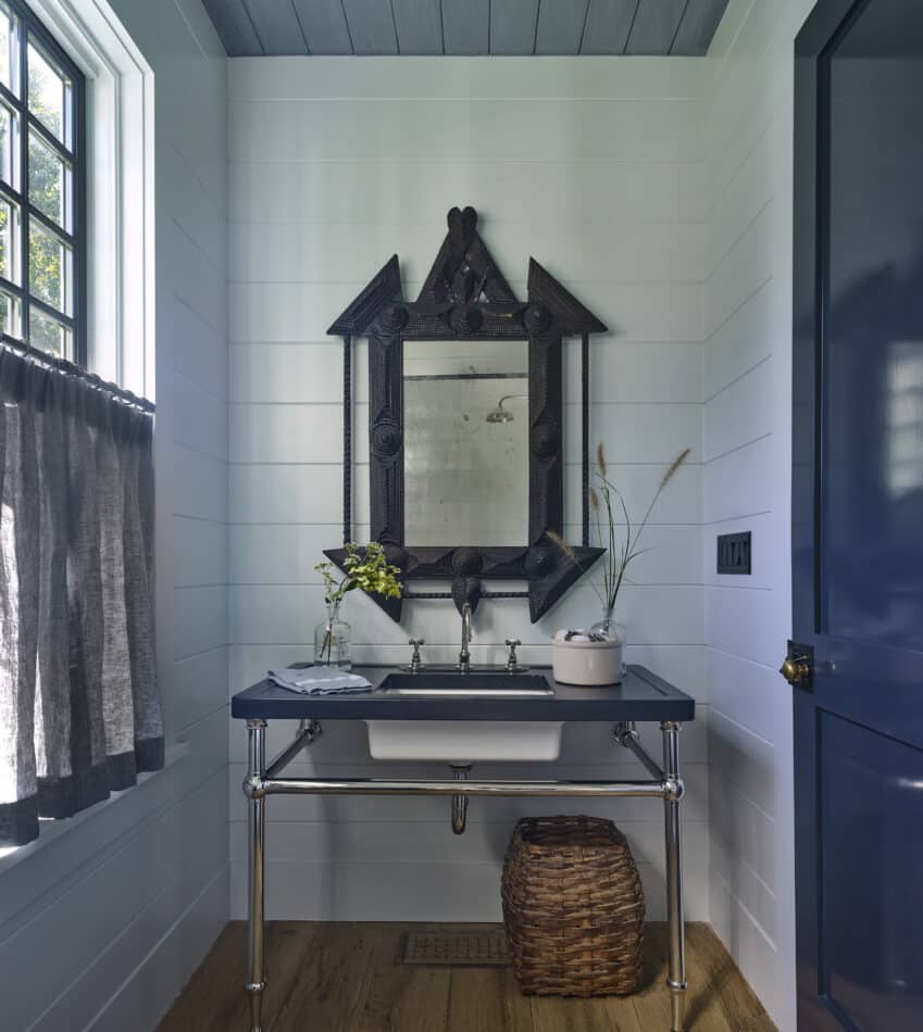 an East Hampton powder room with a tramp art mirror