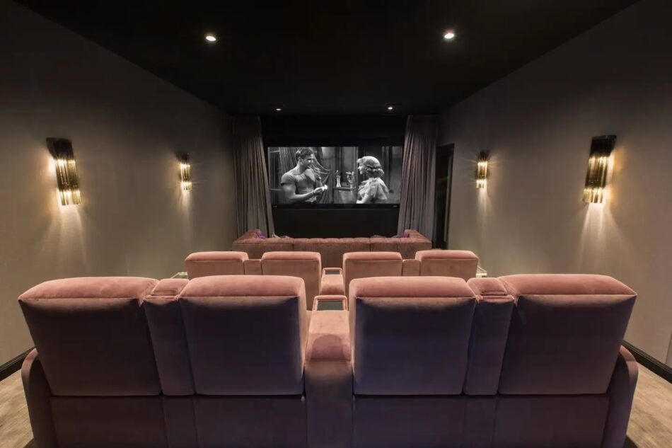 Screening room with blush-colored seating in a Los Angeles home designed by Adam Hunter