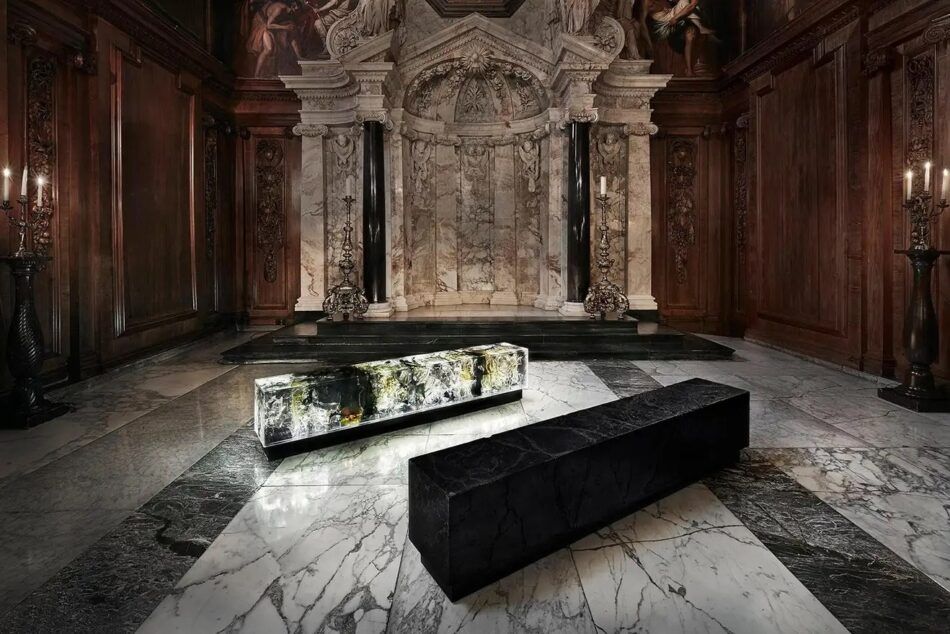 Two monolithic benches by English artist Tom Price — one made of coal, the other made of resin and lit from within by LED lights — on view in the chapel at Chatsworth House, in the UK