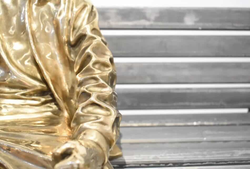 Detail of Huang Yulong’s "Be My Side" sculpture of a bronze figure on a bench
