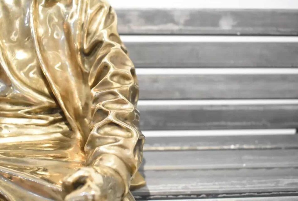 Detail of Huang Yulong’s "Be My Side" sculpture of a bronze figure on a bench