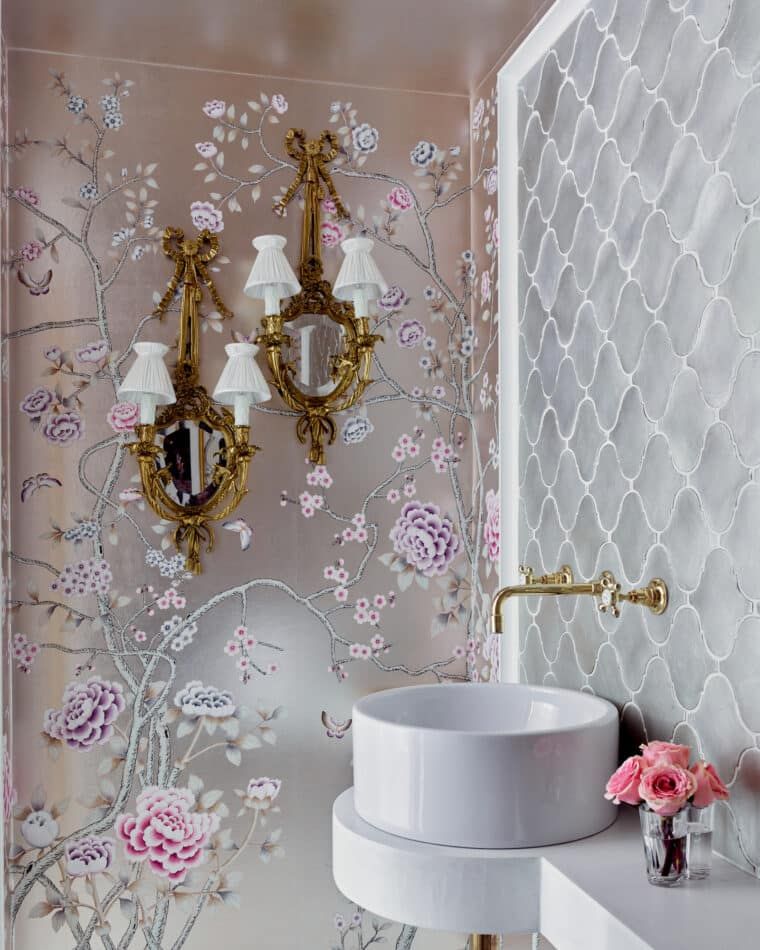 powder room with pink and silver metallic wallpaper and antique giltwood sconces