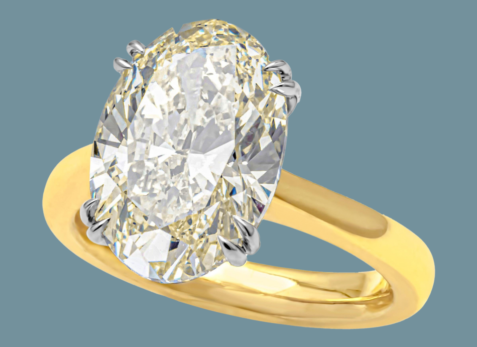 An oval-cut diamond solitaire engagement ring in yellow gold on a blue background 