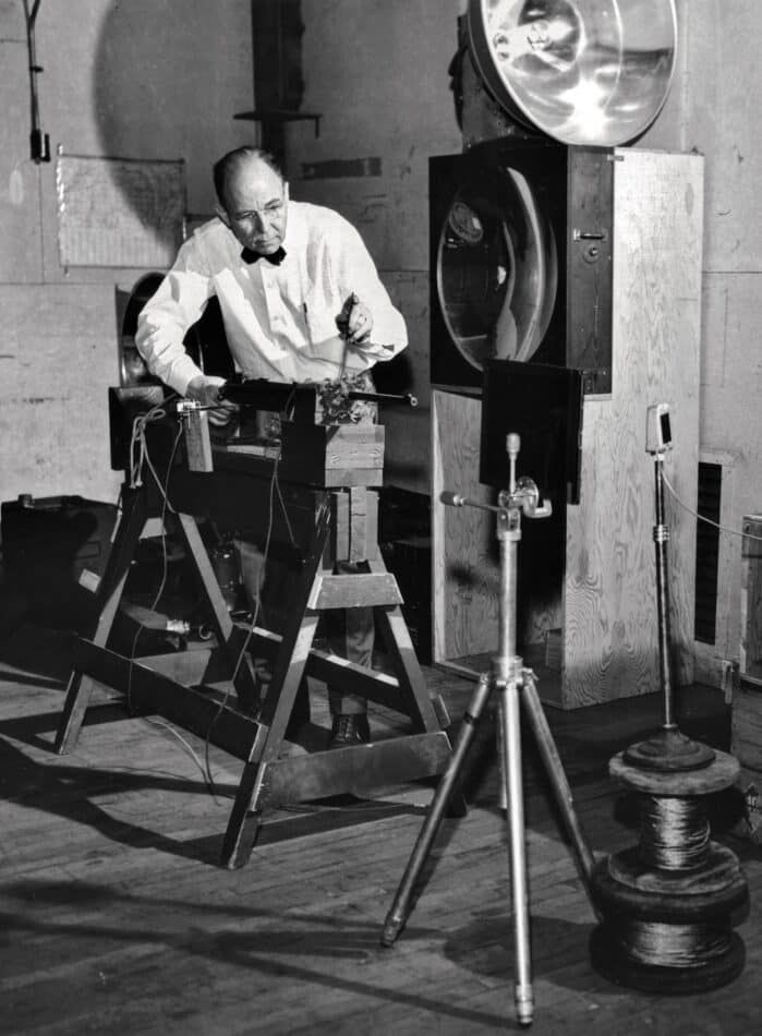 Edgerton setting up a rifle for one of his high-speed photographs of bullets piercing objects.