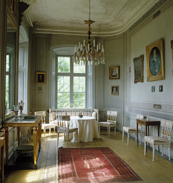 The walls of the Countess's Cabinet are decorated with hand-painted borders and the room is furnished with a suite of white-painted late Gustavian chairs