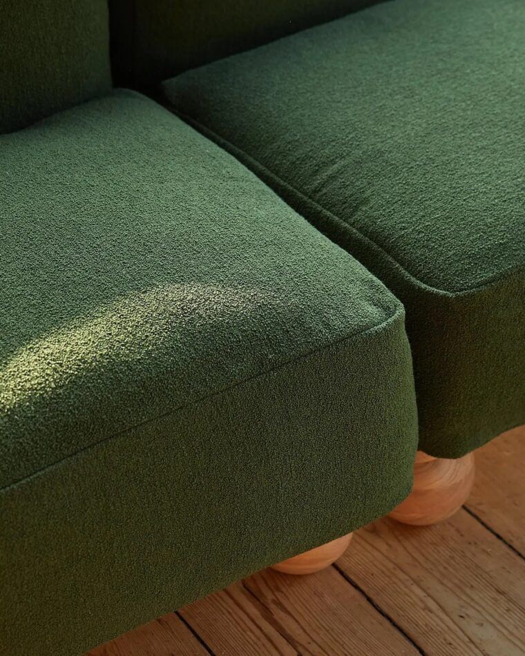 A detail of Fred Rigby Studio’s Cove Slipper 2.5 Seater sofa covered in Woodland Green wool bouclé