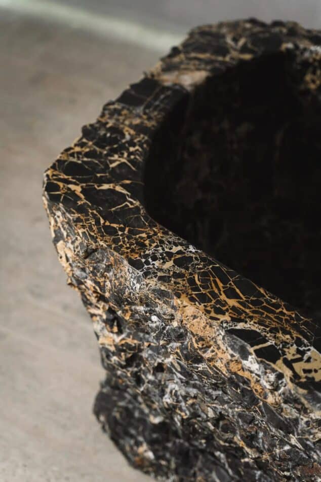 A closeup of the Baptiz rock bathtub in black Portoro marble