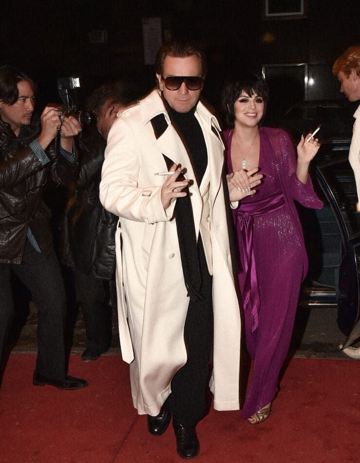 Ewan McGregor as Halston and Krysta Rodriguez as Liza Minelli glide past paparazzi and onlookers to enter Studio 54 in episode four of Halston. 