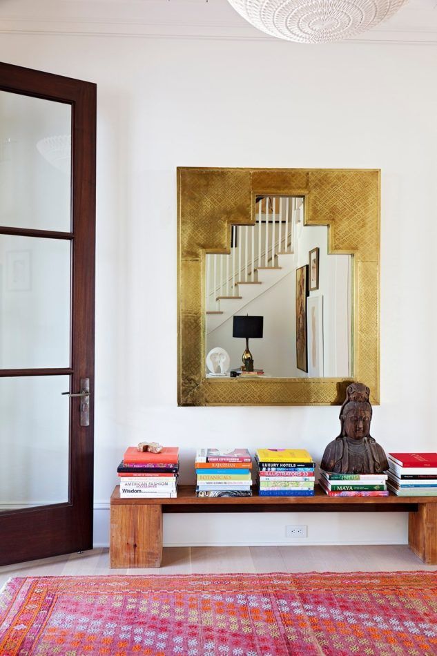 Foyer designed by Angie Hranowsky with a Buddha statue and stacks of books