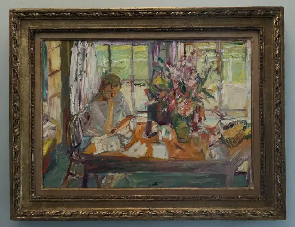 A Wolf Kahn painting of a woman sitting at a table with a large bouquet of flowers in a vase