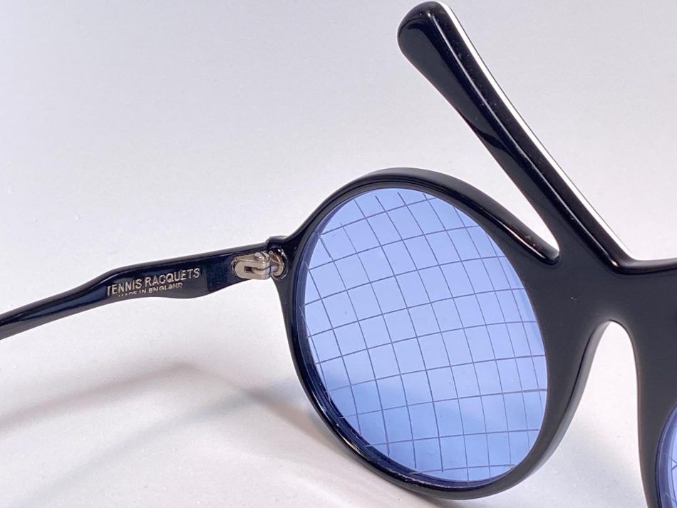 One of the temples of the sunglasses is printed with "Tennis Racquets" and "Made in England."