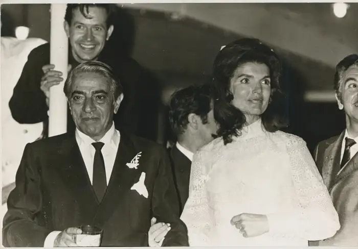 A black-and-white photo of Aristotle Onassis and Jackie Kennedy Onassis at their wedding reception