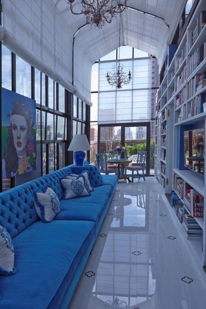 The library of this New York penthouse by John Barman boasts a glossy white floor with a quatrefoil pattern.