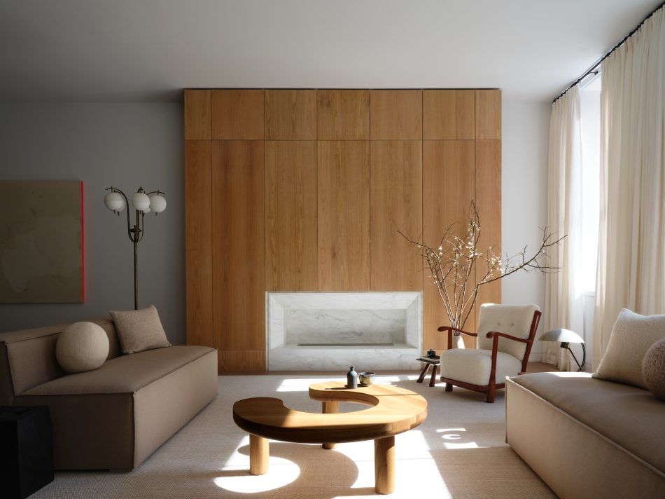 In the main living space of a Soho loft, Christina Cole gave the white-marble fireplace architectural presence by enfolding it in vertical oak panels.