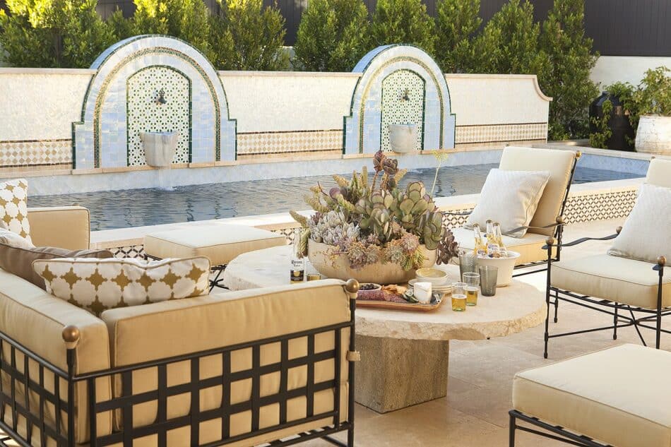 a regal patio in front of a pool with fountains