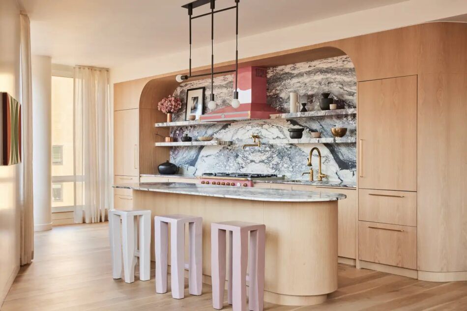 Blond-wood kitchen with a pink stove in an apartment in New York’s Chelsea neighborhood designed by Le Whit