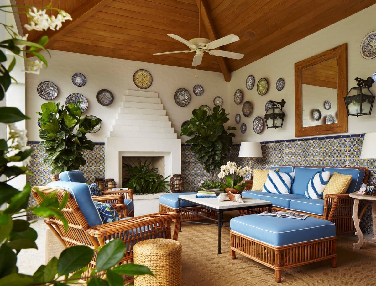 An elegant patio in a Palm Beach residence by Celerie Kemble has comfortable rattan seating.