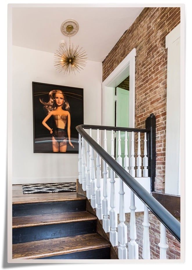 Stairway landing in Lucinda Loya's own home with large photo of Barbie on the wall