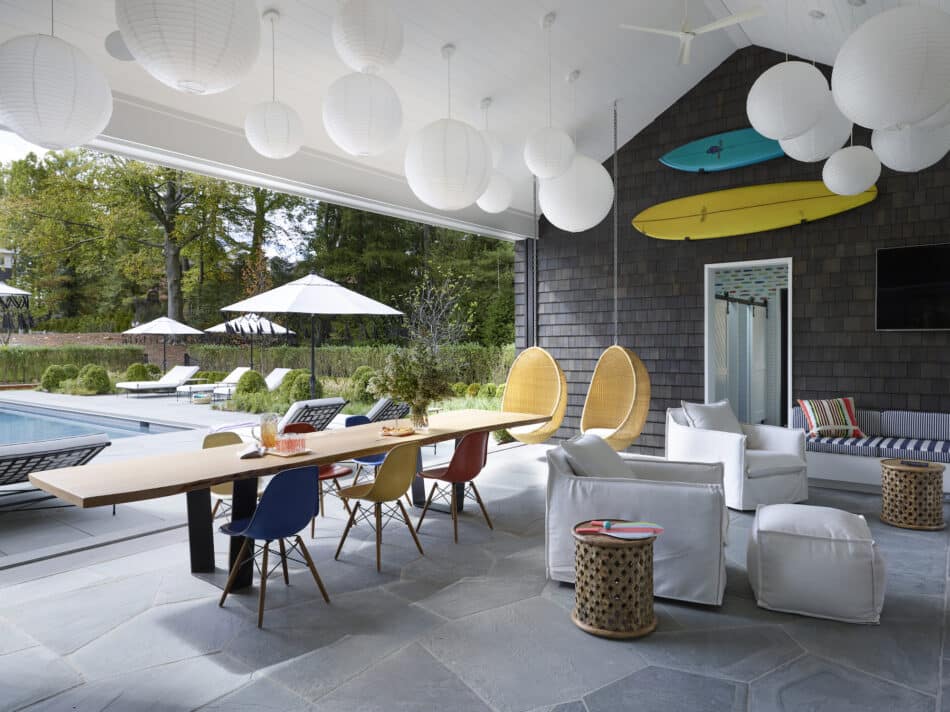 A pool house with interiors by Fawn Galli, including colorful Eames shell chairs