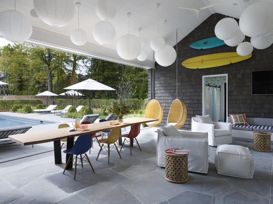 A pool house with interiors by Fawn Galli, including colorful Eames shell chairs