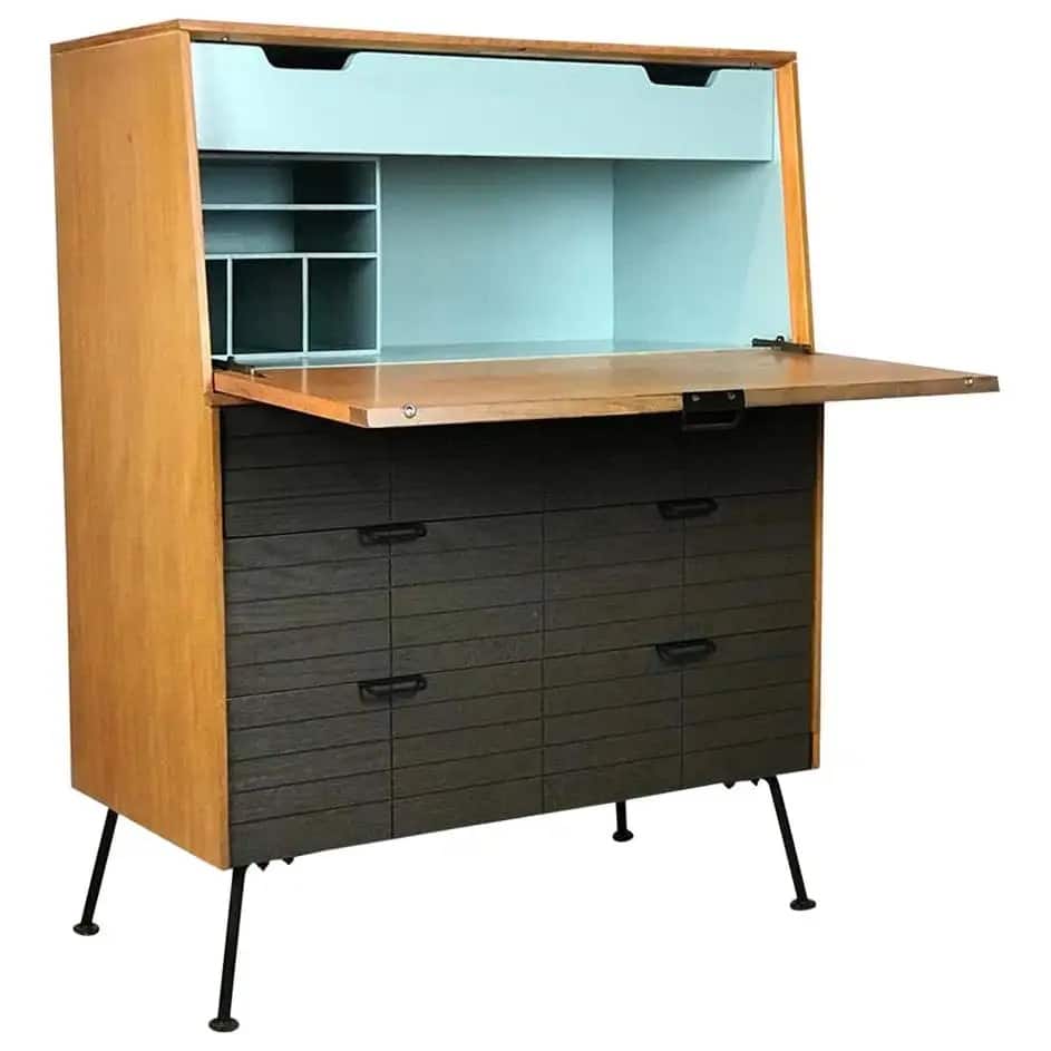 A stream-lined, wood-framed secretary by Raymond Loewy with a light-blue metal interior on the top and darker stained drawers on the bottom portion