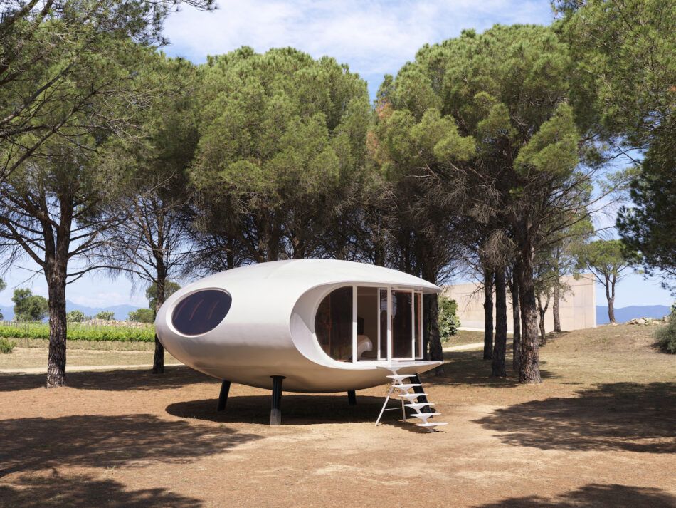 A white, pod-shaped prefab home by Greek architect Nikolaos Xasteros on the grounds of Terra Remota vineyard in Spain