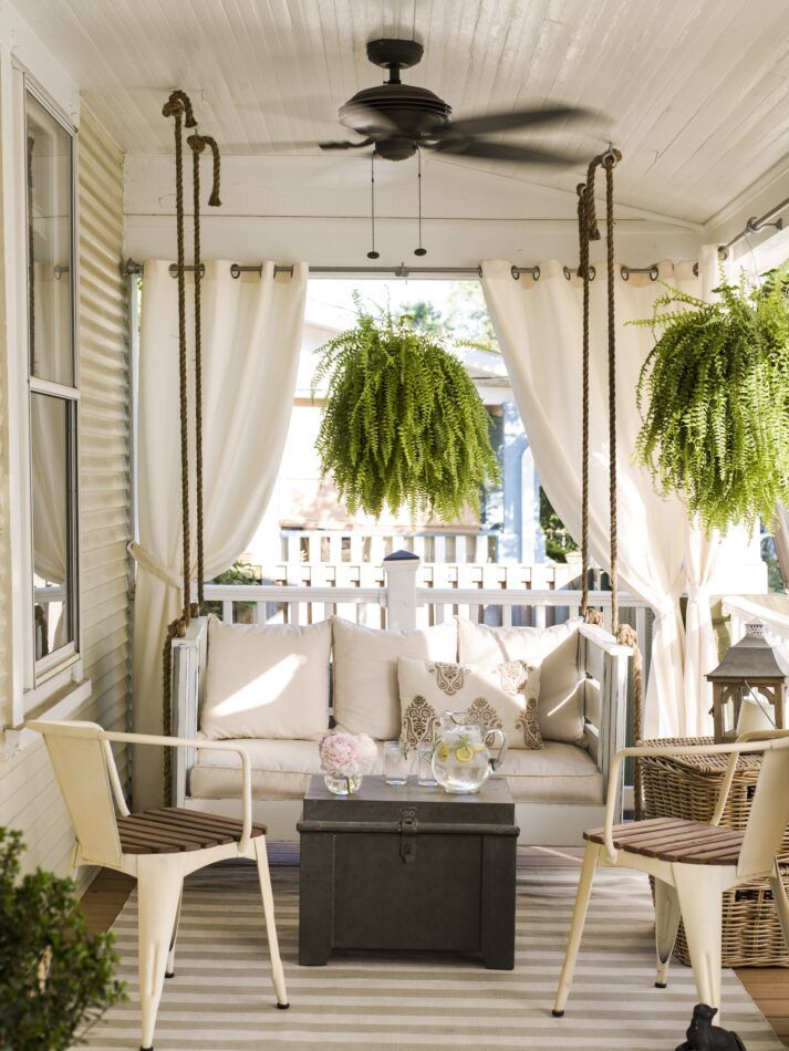 a patio with a swing and two chairs