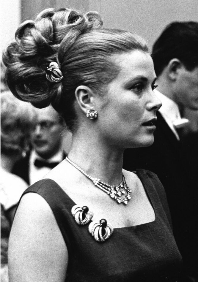 A black-and-white photo of Princess Grace of Monaco wearing three Cartier ruby and diamond clips