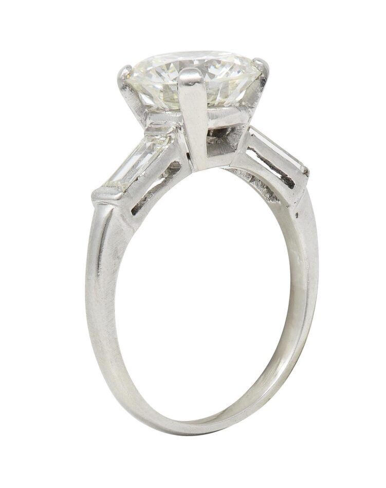 A platinum engagement ring with a four-prong setting and transitional cut diamond