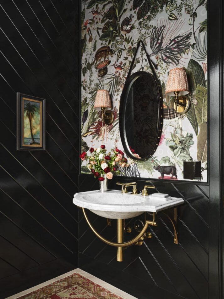 a dark powder room with floral wallpaper
