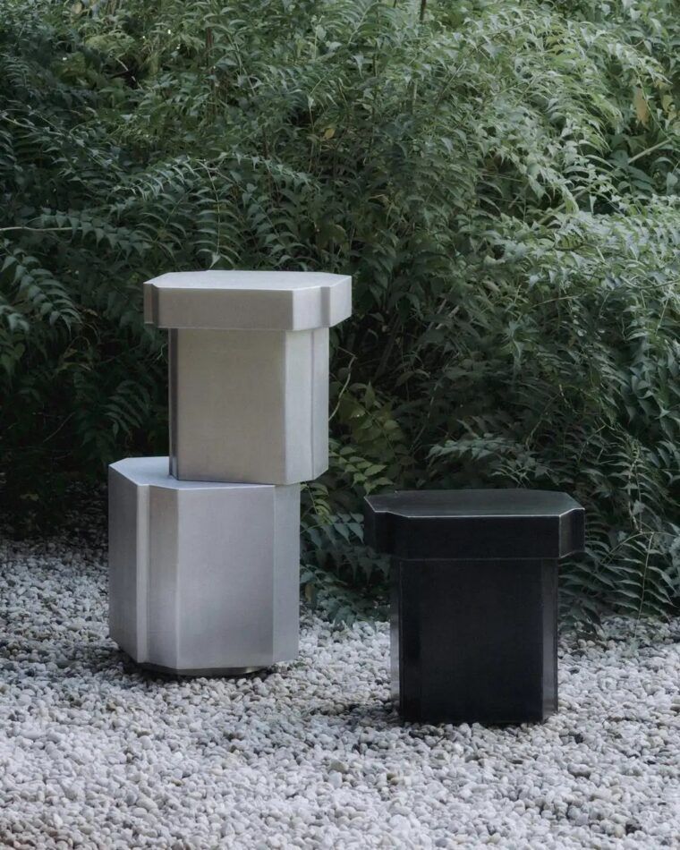 Louise Roe's Funki 1 (left, on bottom) and Funki 2 tables photographed outdoors in front of green foliage