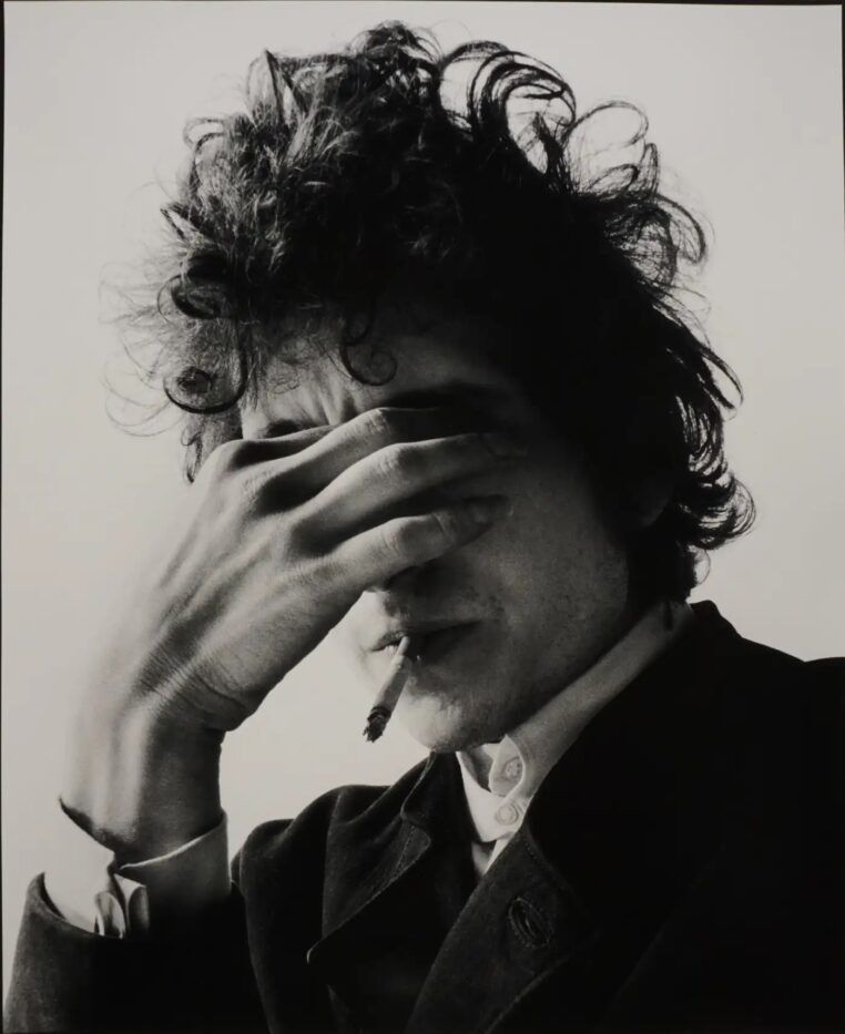Bob Dylan holds his hand to his eyes in the photograph Smoke by Jerry Schatzberg.