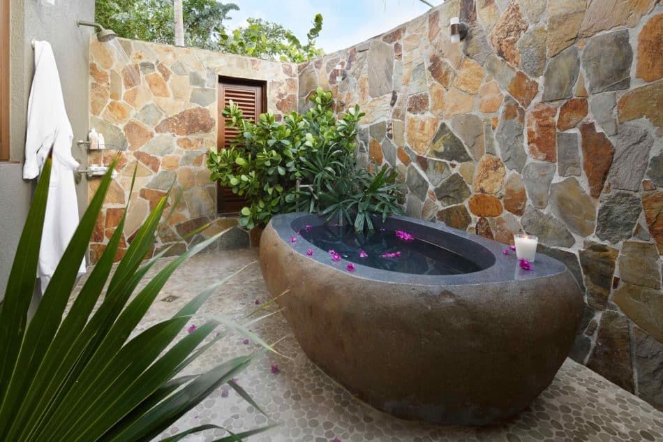 Outdoor stone bathtub and shower by Soucie Horner
