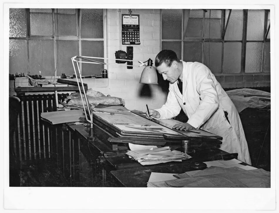 A circa 1938 black-and-white photo of Ken Hampton, an employee at Herbert Terry & Sons, with a Model 1208 lamp
