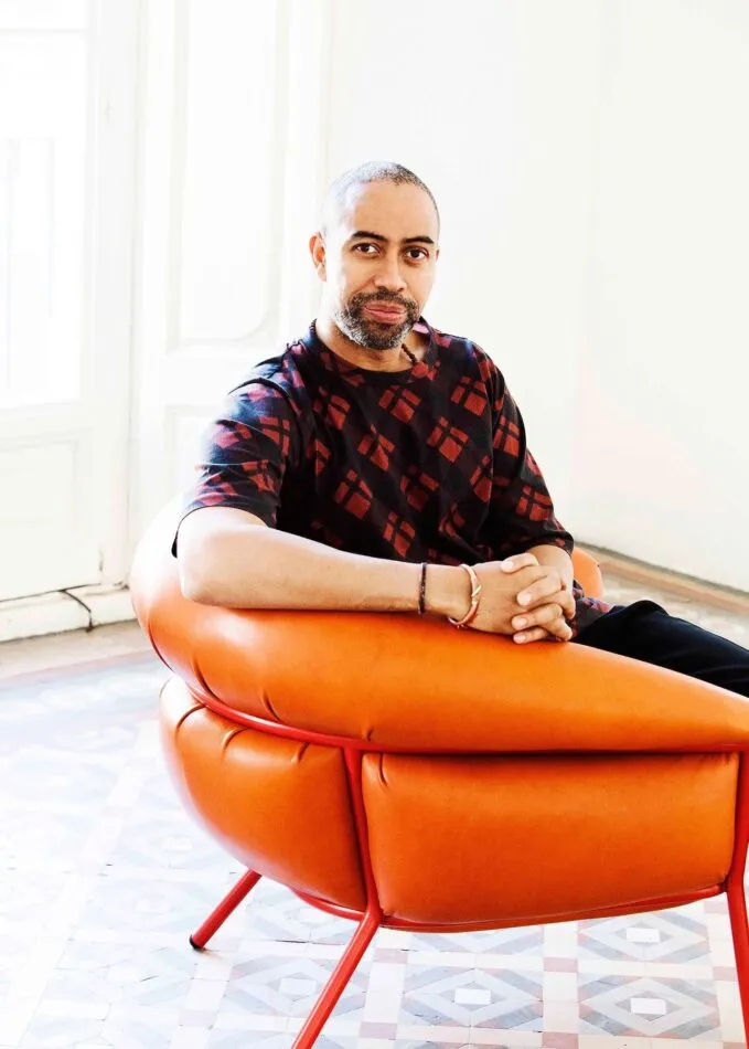 Furniture designer Stephen Burks sitting in his Grasso armchair