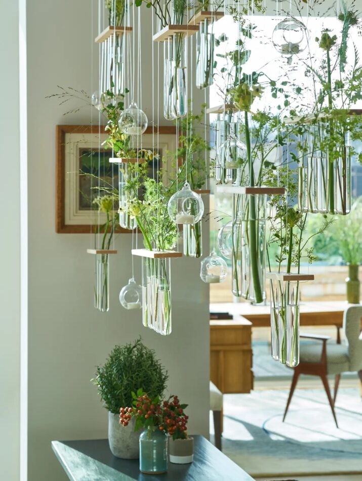A hanging screen made of plant cuttings in glass test tubes in a central London penthouse designed by Susie Atkinson