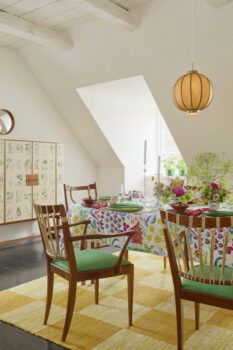 Dining table with wood chairs, yellow rug, and Flora cabinet