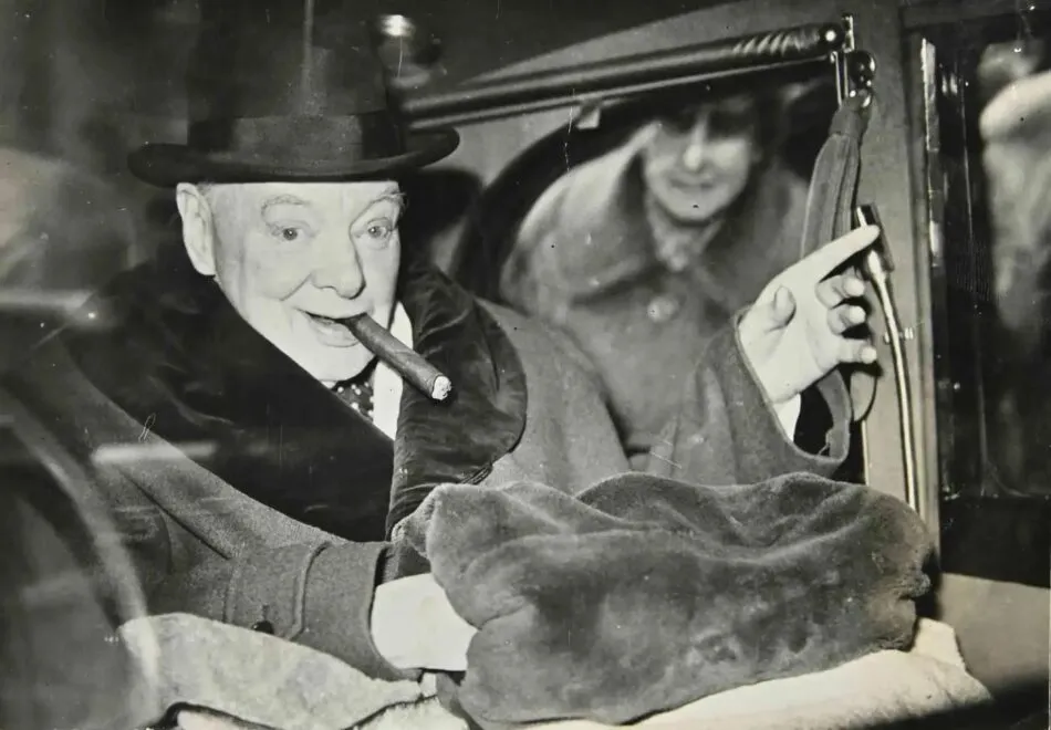 Winston Churchill with top hat smoking a cigar in a limousine. 