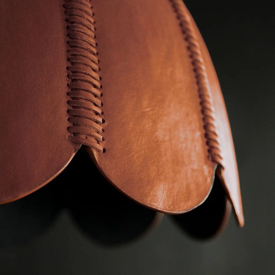A closeup of the whipstitched details on the L'Aviva Home Doma leather pendant light in camel