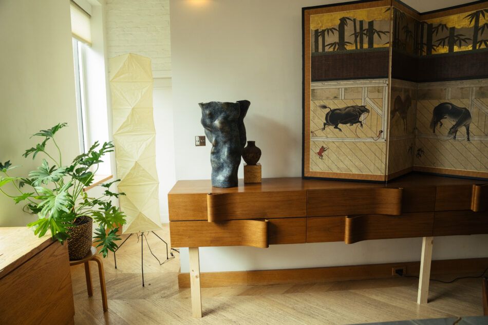 apartment with wood credenza, noguchi lamp, and artek stool with plant 