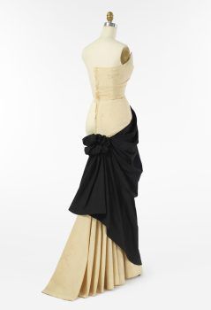 Mannequin wearing a cream dress with black draped detail